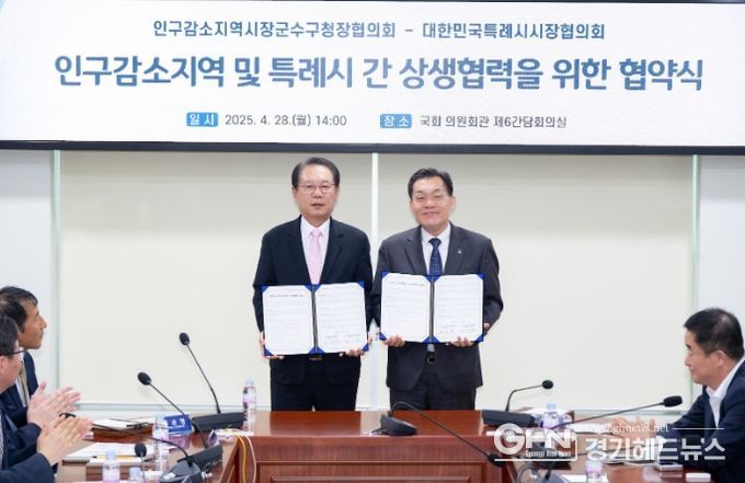 이재준 수원시장(오른쪽)과 송인헌 괴산군수가 협약 체결 후 기념촬영을 하고 있다.