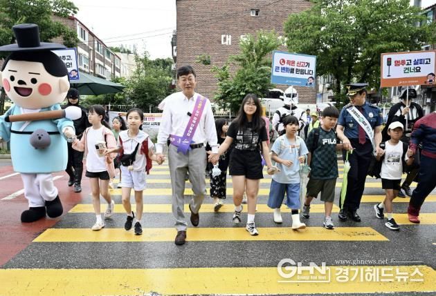 이민근 안산시장(맨 앞줄 왼쪽 네번 째)이 15일 고잔초등학교 앞에서 등교하는 어린이들의 손을 잡고 안전하게 횡단보도를 건너고 있다.