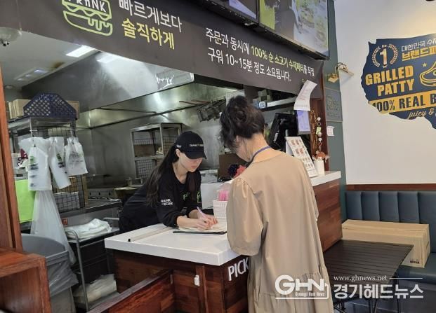 성남시 어린이 기호식품 전담관리원이 지난 9월 학교 주변 햄버거 판매점에서 영업자와 종업원의 건강진단 실시 여부를 점검하고 있다