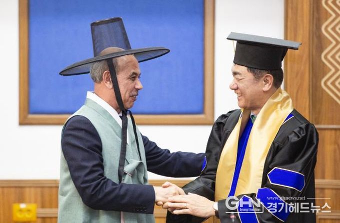 정장선 평택시장이 대학 명예교수로 임명된 가운데, 평택시가 선물한 한복을 입은 툴킨 테샤바예프 총장과 악수를 나누고 있다.